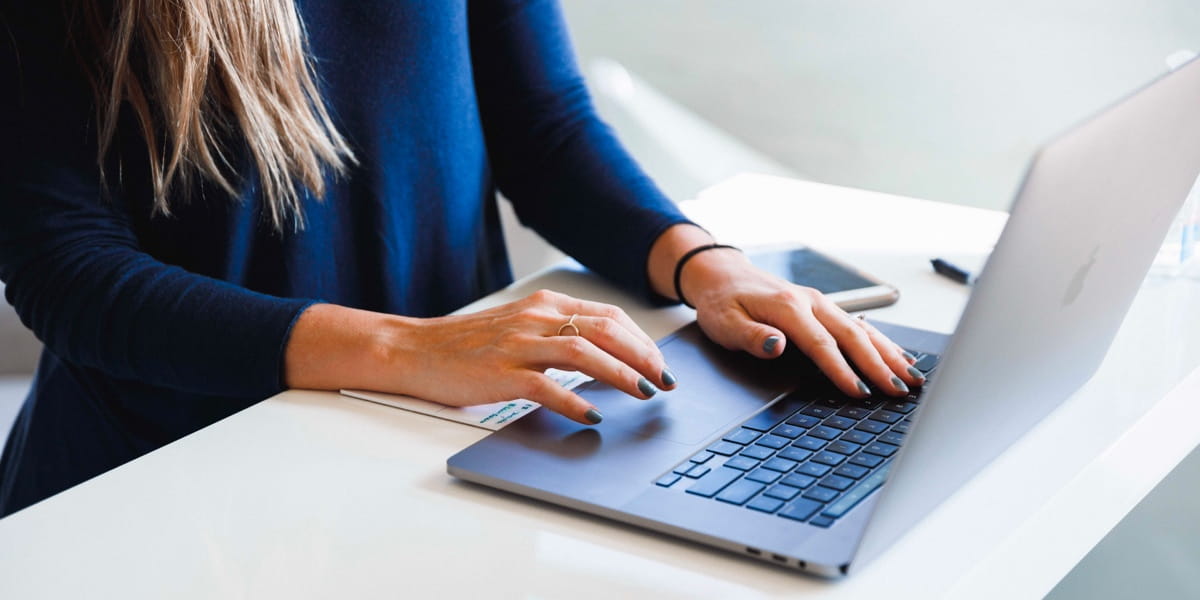 Person writing at a laptop